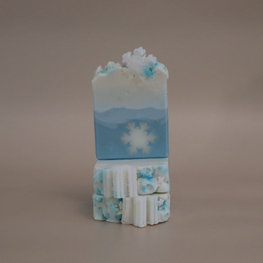 Stack of blue and white soap bars with snowflake design on a beige background