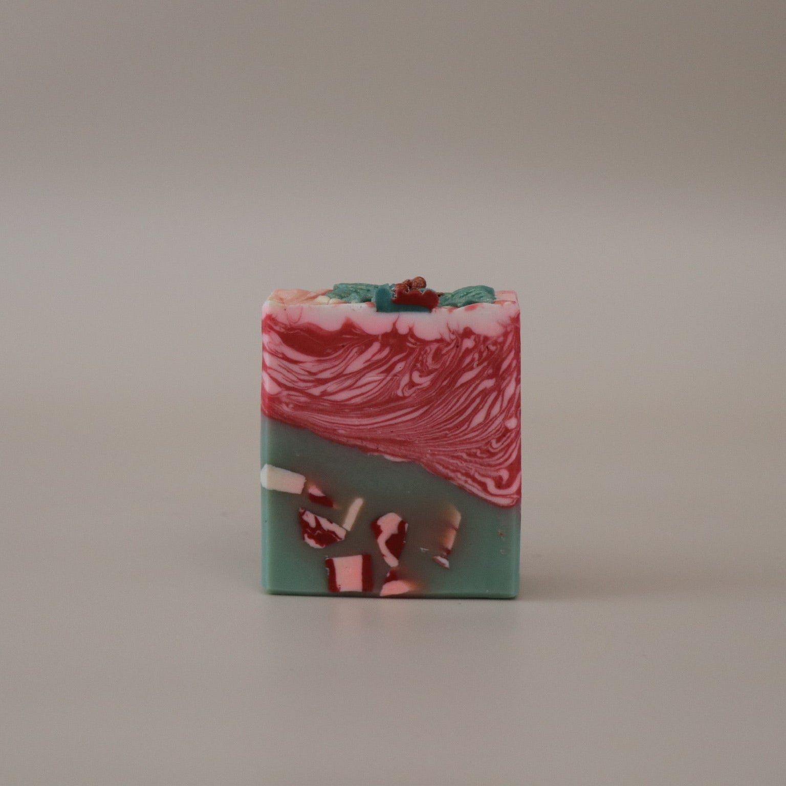 Marbled soap bar with red and green colors on a beige background