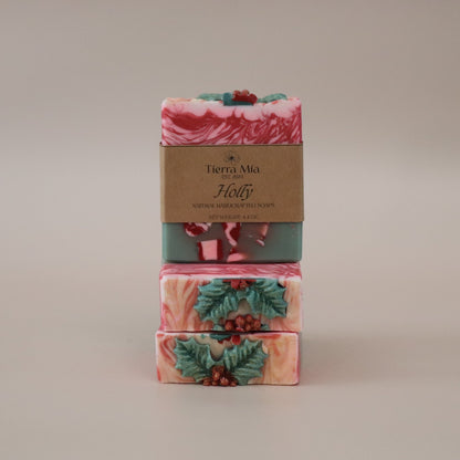 Stack of three soap bars with decorative packaging on a beige background