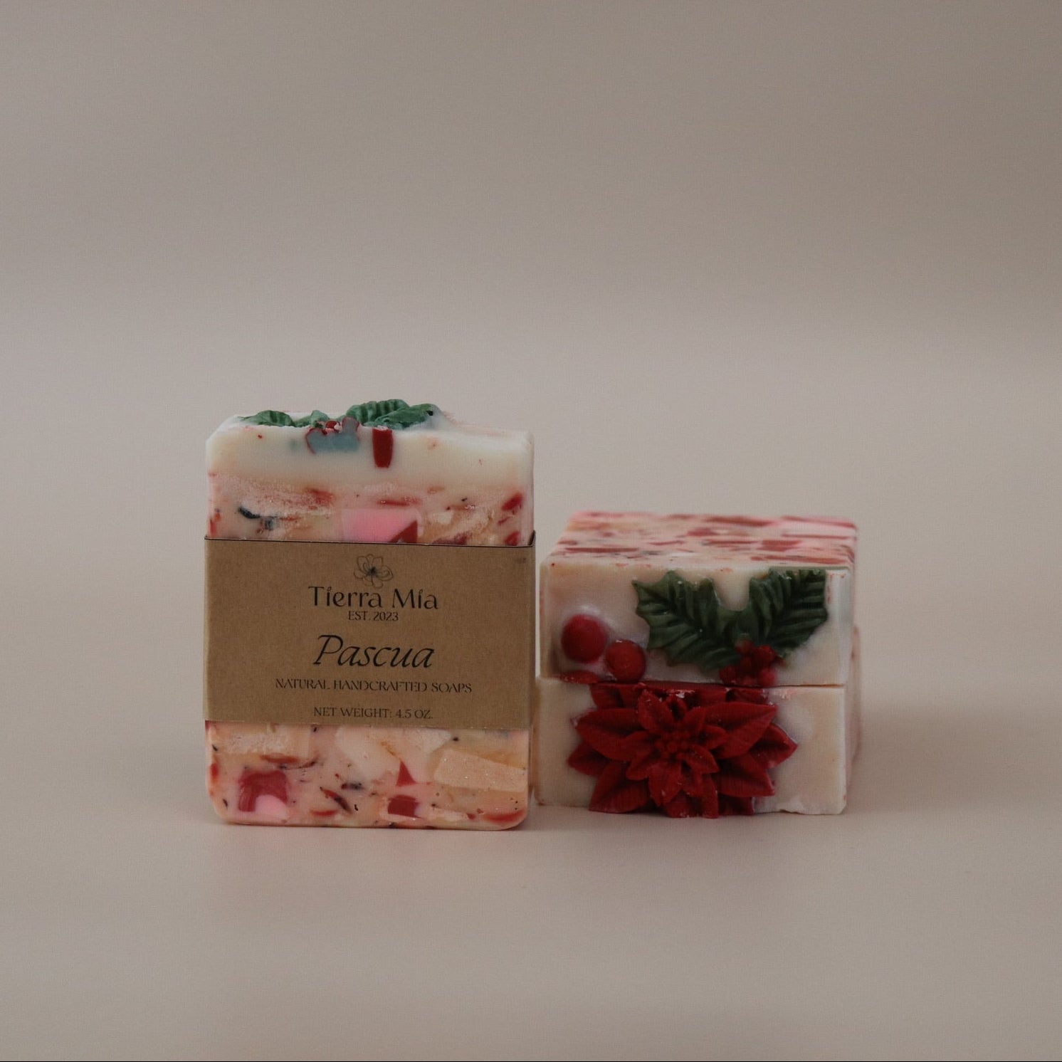 Two decorative soap bars with Christmas-themed designs on a plain background