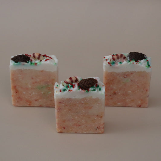 Three square-shaped candies with a orange and white color scheme on a beige background