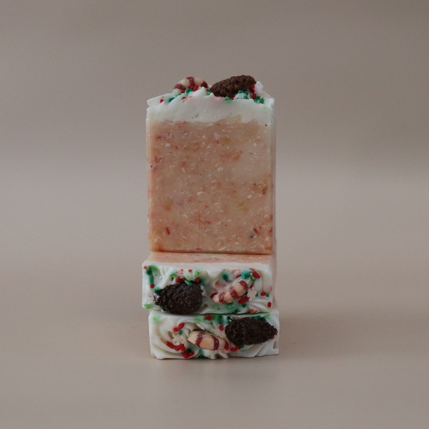 Two stacked soap bars with decorative elements on a beige background
