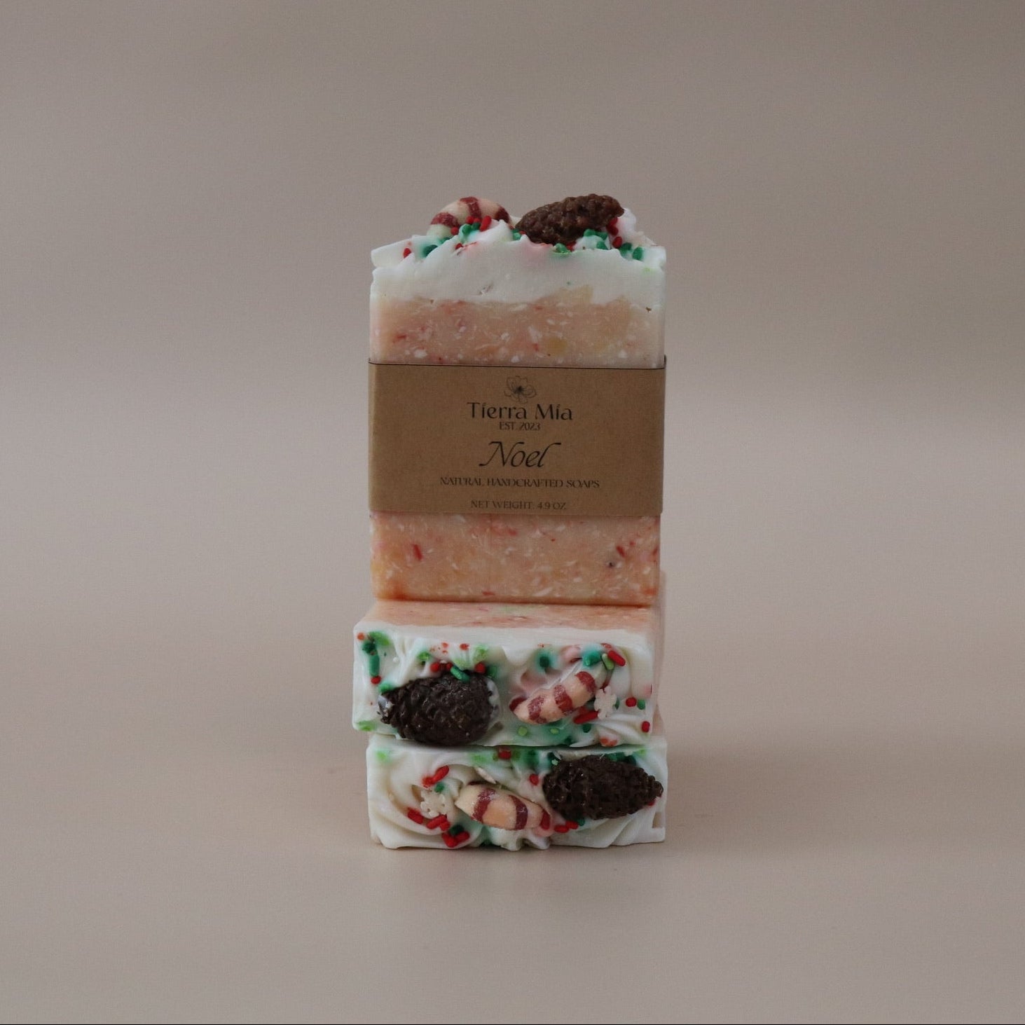 Two bars of soap with decorative toppings on a neutral background