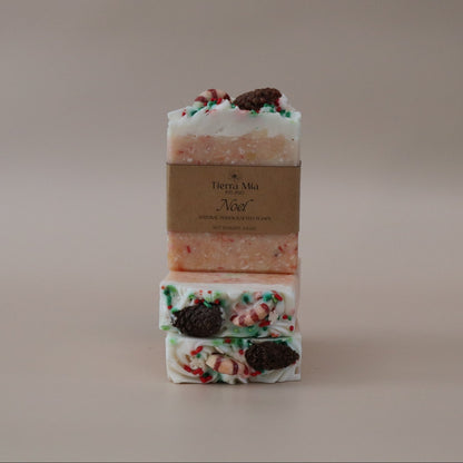 Two bars of soap with decorative toppings on a neutral background