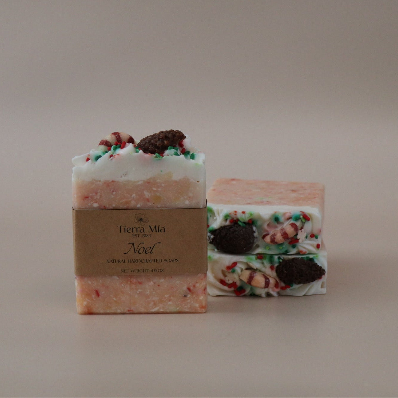 Two soap bars with decorative toppings on a plain background