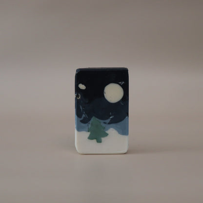 Small rectangular ceramic piece with a night sky design featuring a moon and tree on a beige background
