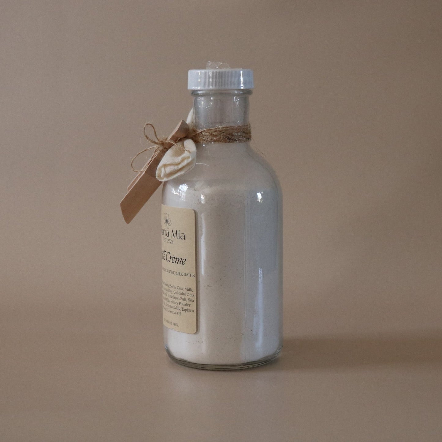 Jar of milk bath with a label on a beige background