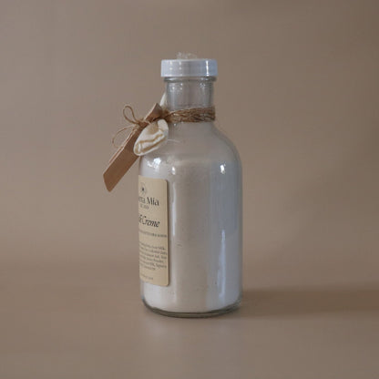 Jar of milk bath with a label on a beige background