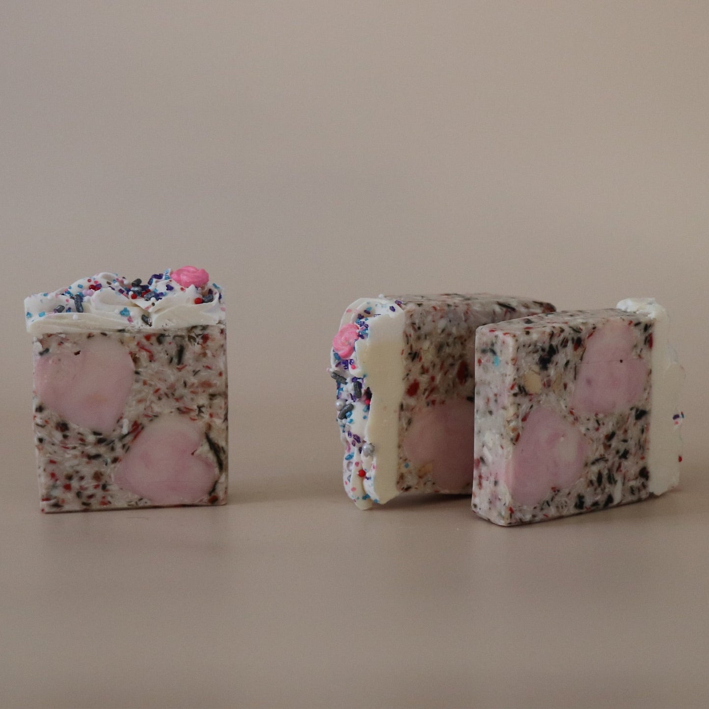 Two  soaps on a beige surface with a neutral background