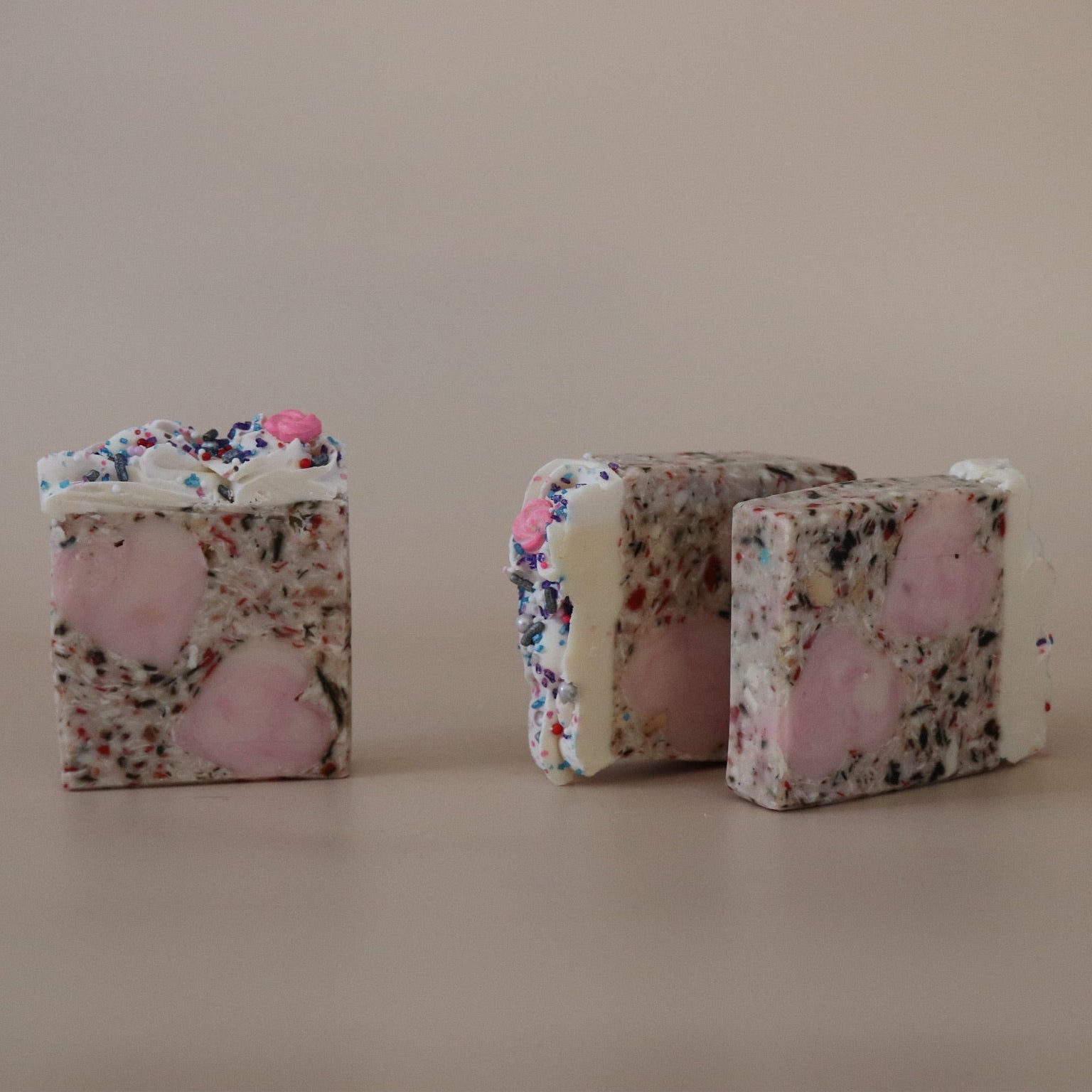 Two  soaps on a beige surface with a neutral background